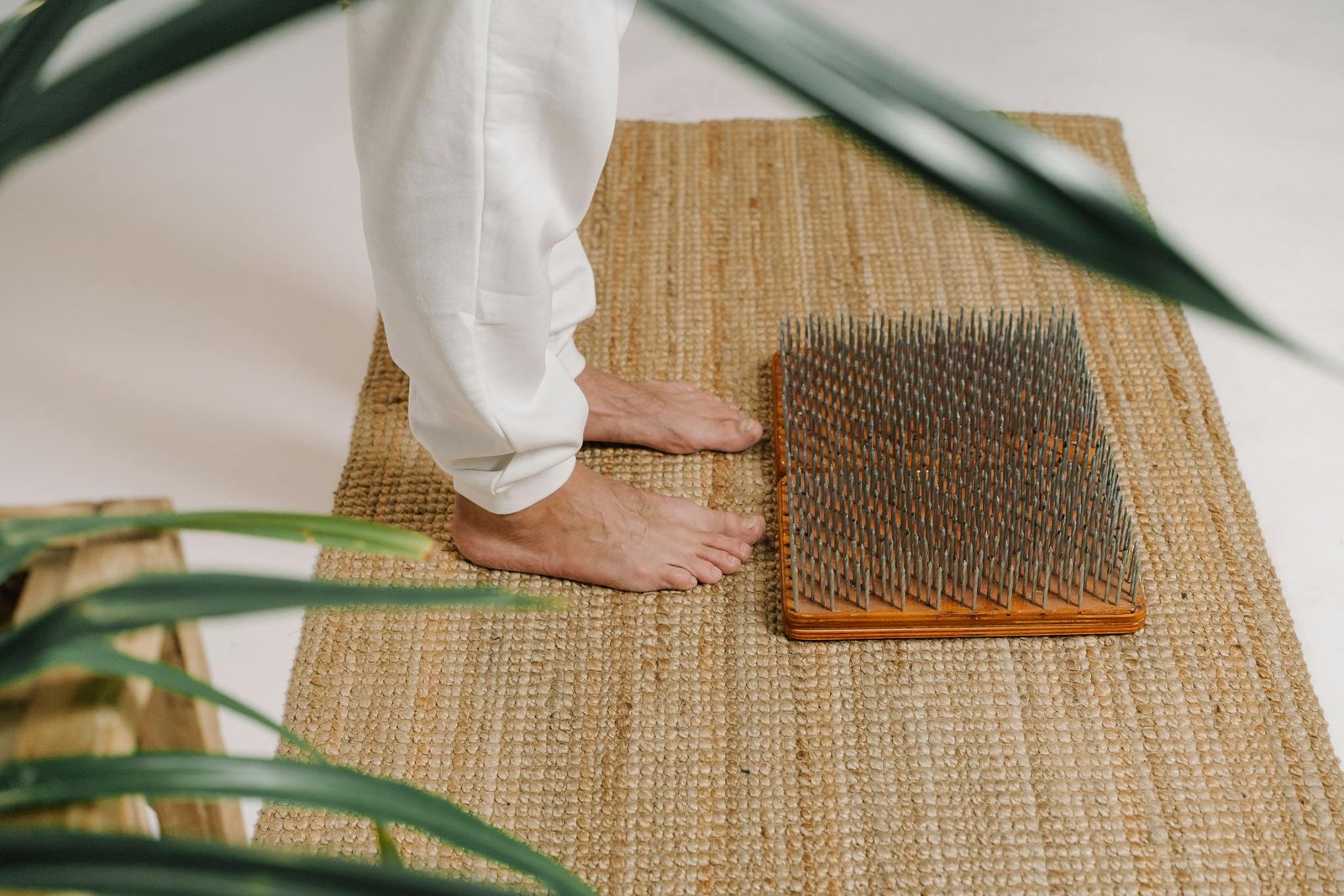 Barefoot acupressure practice on nail board to promote relaxation and meditation indoors.