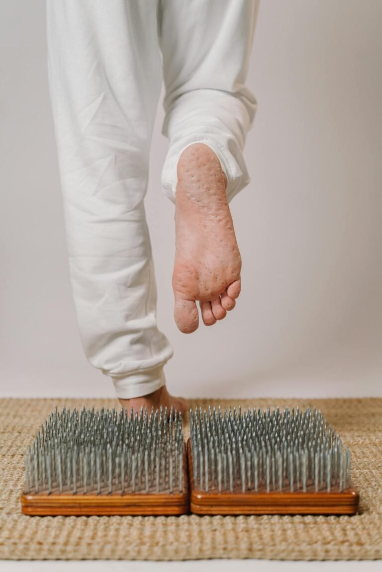 Close-up of a person practicing yoga on a nail board for foot therapy, promoting health and mindfulness.